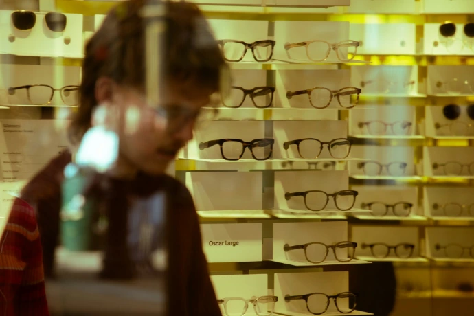 A person looking at glasses in a store display.